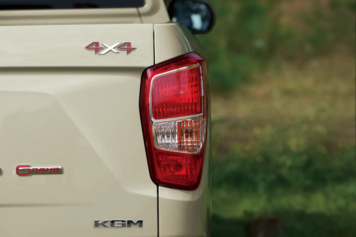 The rear light and 4x4 and Grand badges on a Sandstone Beige KGM Musso Grand