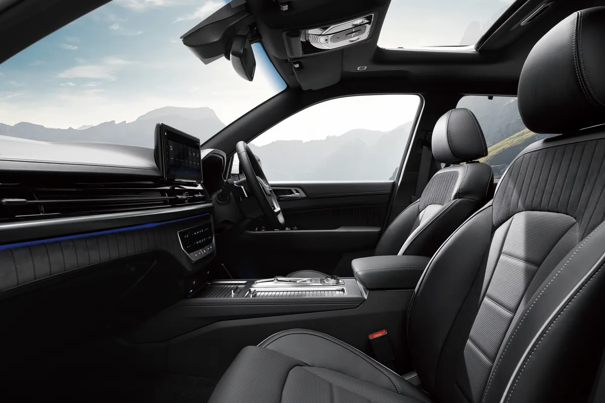 The black leather front seats and dashboard of a KGM Rexton