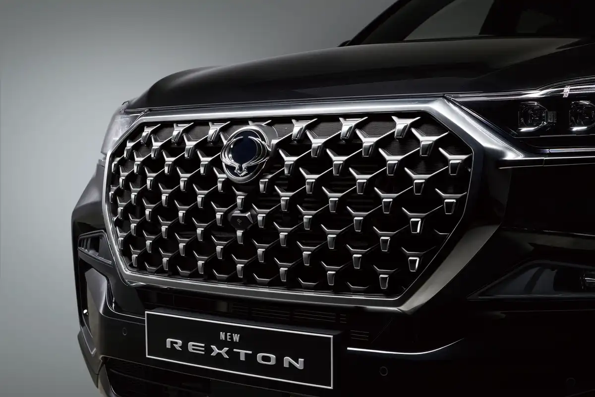 The diamond-pattern grille and NEW REXTON plate of a black KGM Rexton