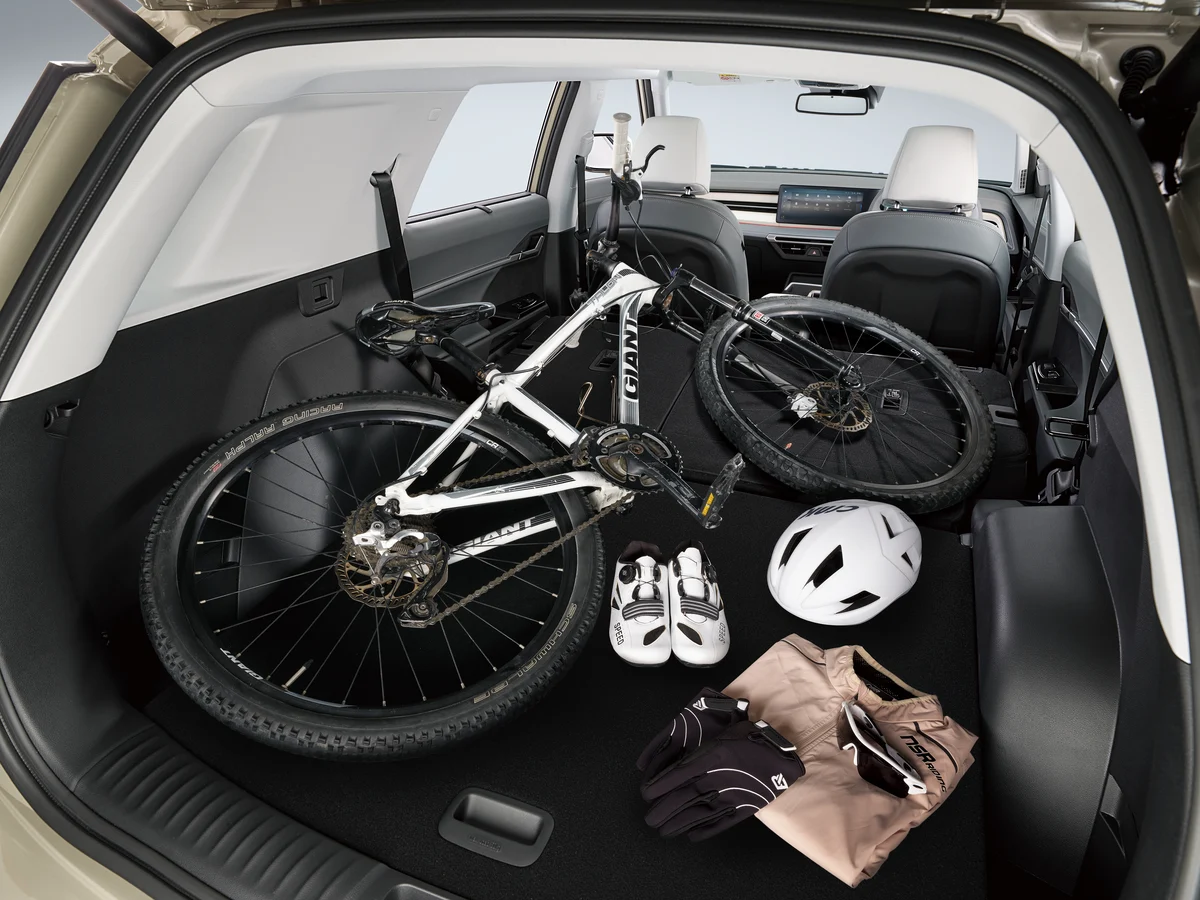 The cargo area of a KGM Torres with the rear seats folded flat, holding a mountain bike