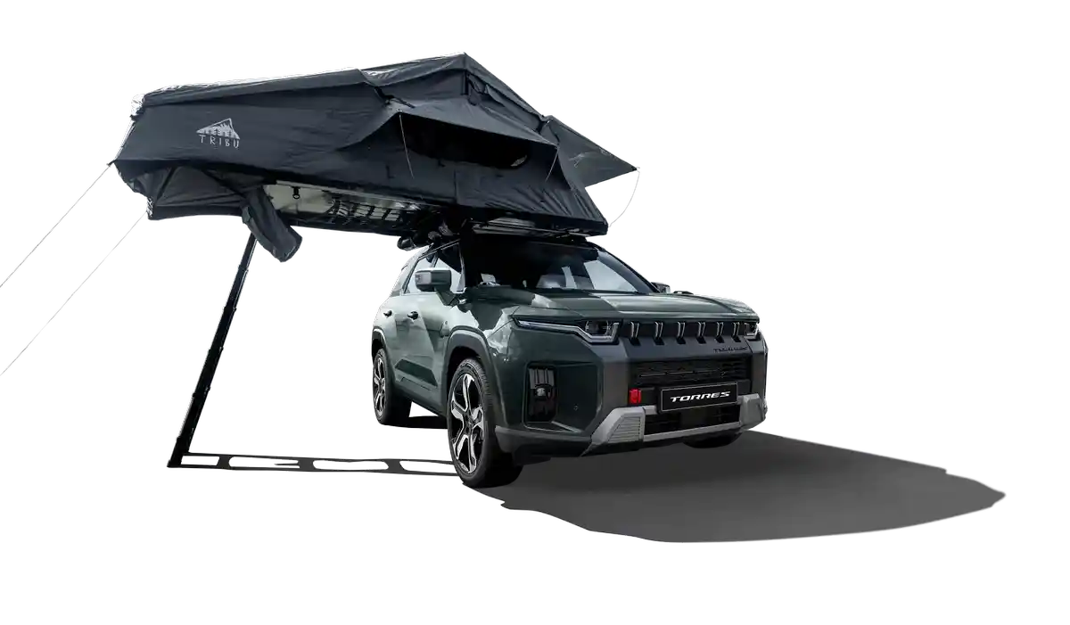 A Forest Green KGM Torres Hybrid with a rooftop tent unfolded over its side